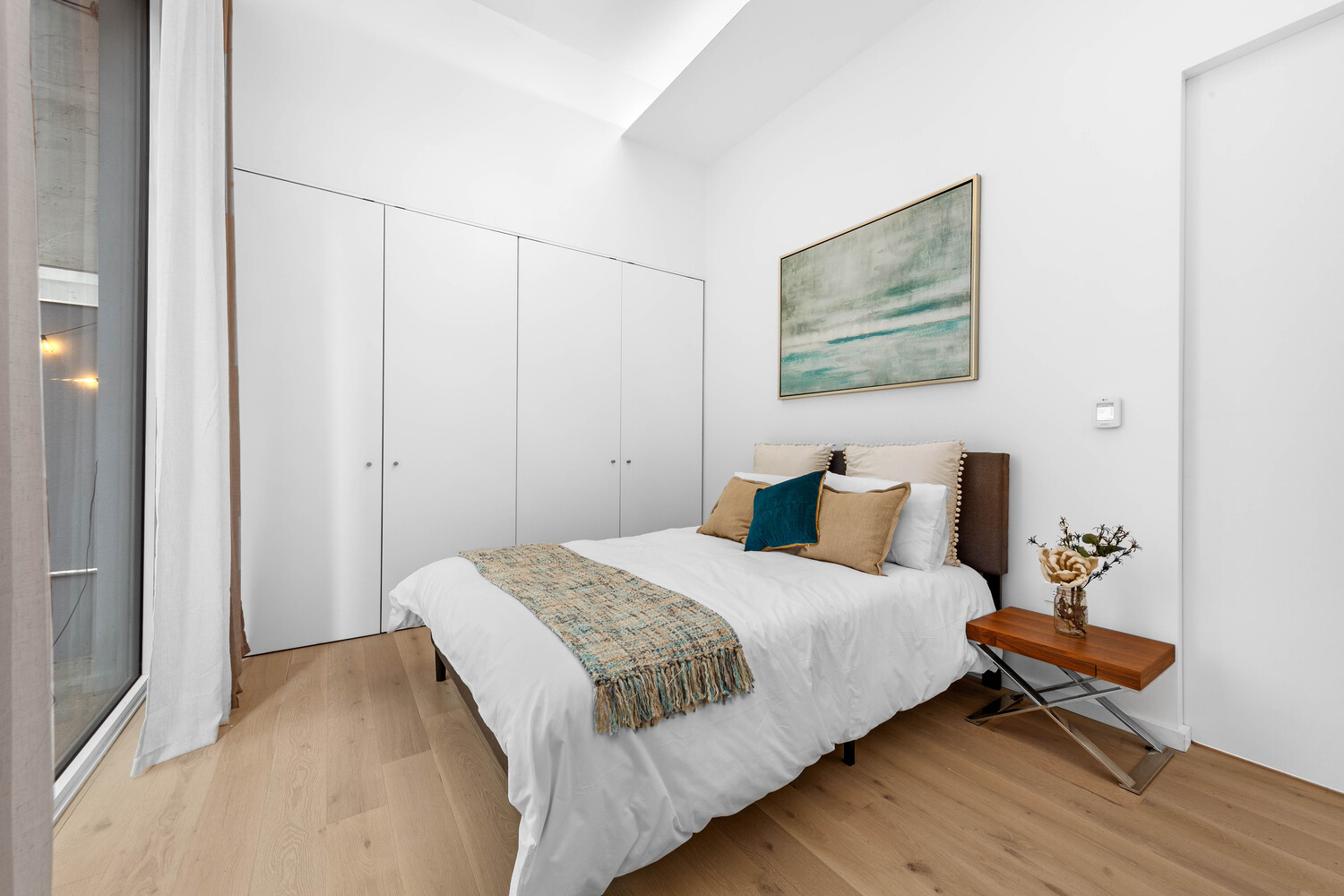 330 Grand Street, Unit 1B Manhattan, NY 10002 - Photo 6 of 14 a bedroom with a bed and a painting on the wall