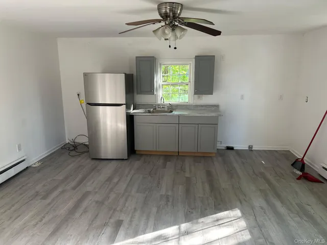 a kitchen with kitchen island wooden floors appliances and window