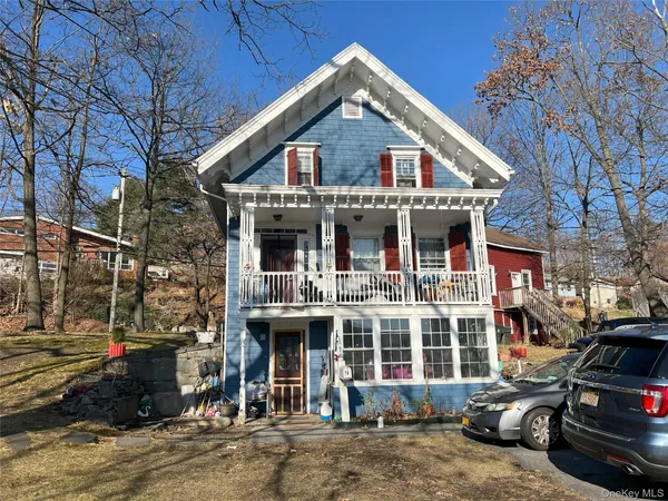 a front view of a house with a yard and parking space