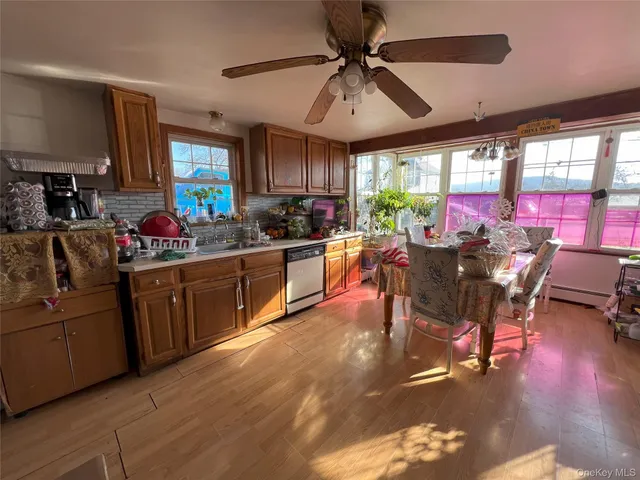 a kitchen with stainless steel appliances granite countertop a stove dining table chairs and window
