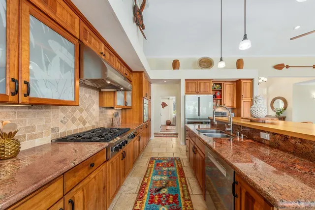 a kitchen with counter top space a stove and wooden floor