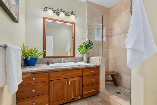 a bathroom with a granite countertop sink a toilet and mirror