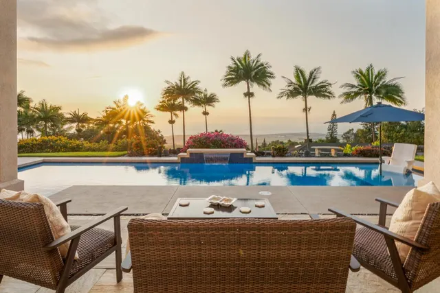 a roof deck with couches and ocean view