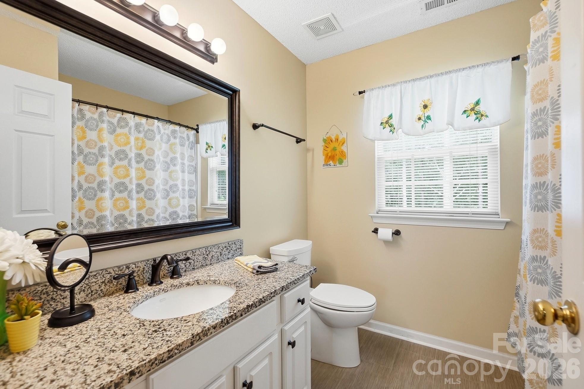 442 Sugar Maple Drive Tega Cay, SC 29708 - Photo 26 of 48 a bathroom with a granite countertop sink mirror vanity and toilet