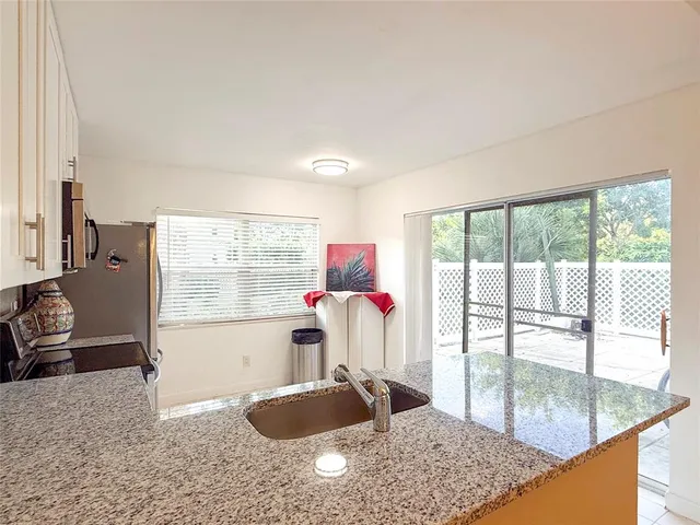 a kitchen with granite countertop a sink and a refrigerator