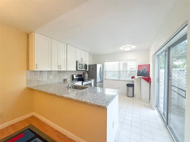 a kitchen with stainless steel appliances granite countertop a granite counter tops and a view of living room