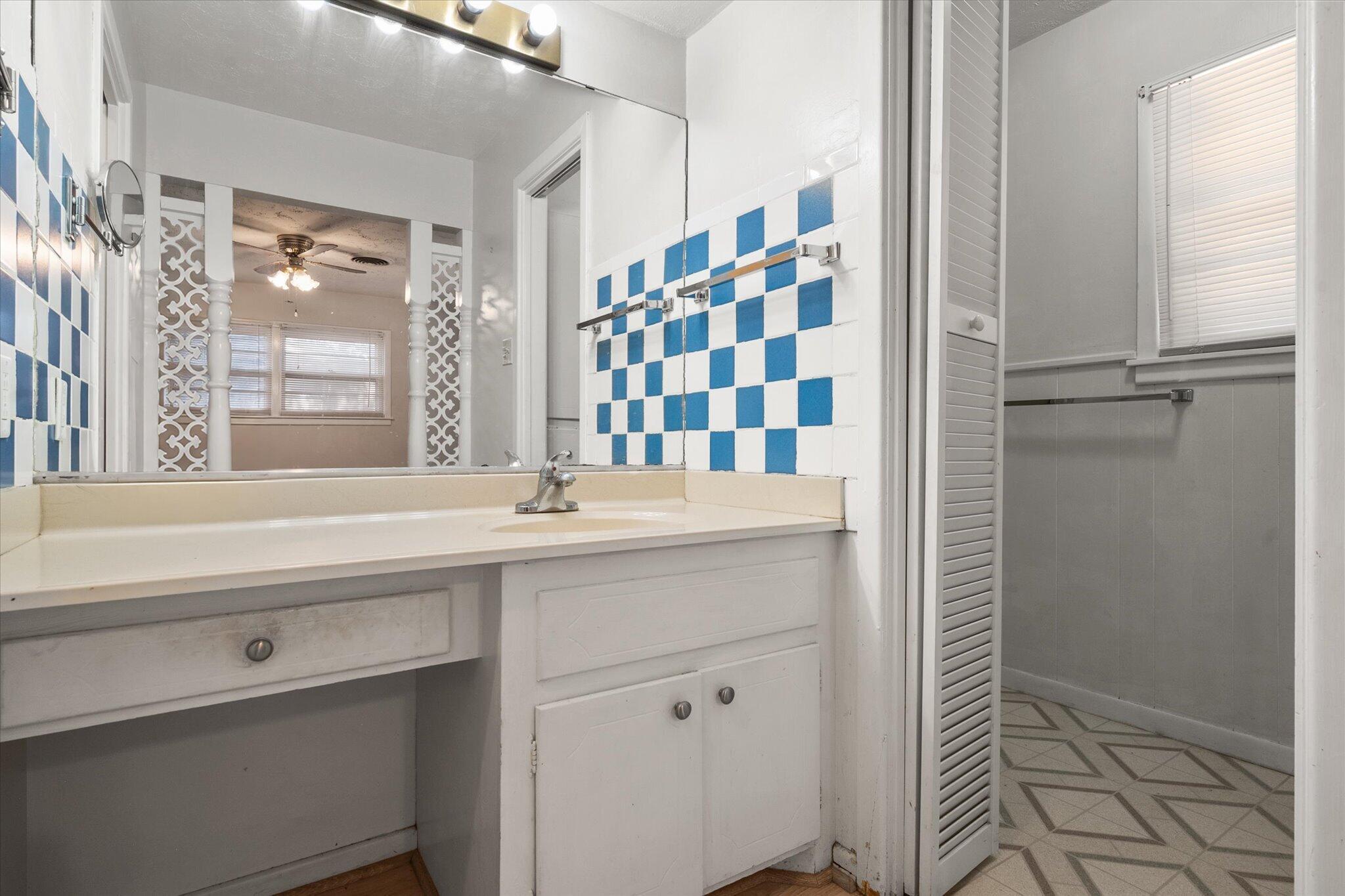 4604 27th Street Lubbock, TX 79410 - Photo 15 of 36 a bathroom with a sink a mirror and a shower