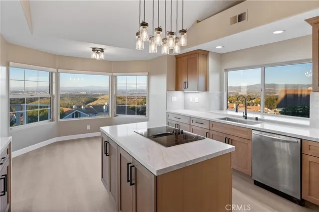 a large kitchen with stainless steel appliances lots of counter space and wooden floor