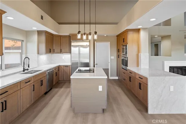 a kitchen that has a lot of cabinets in it and stainless steel appliances