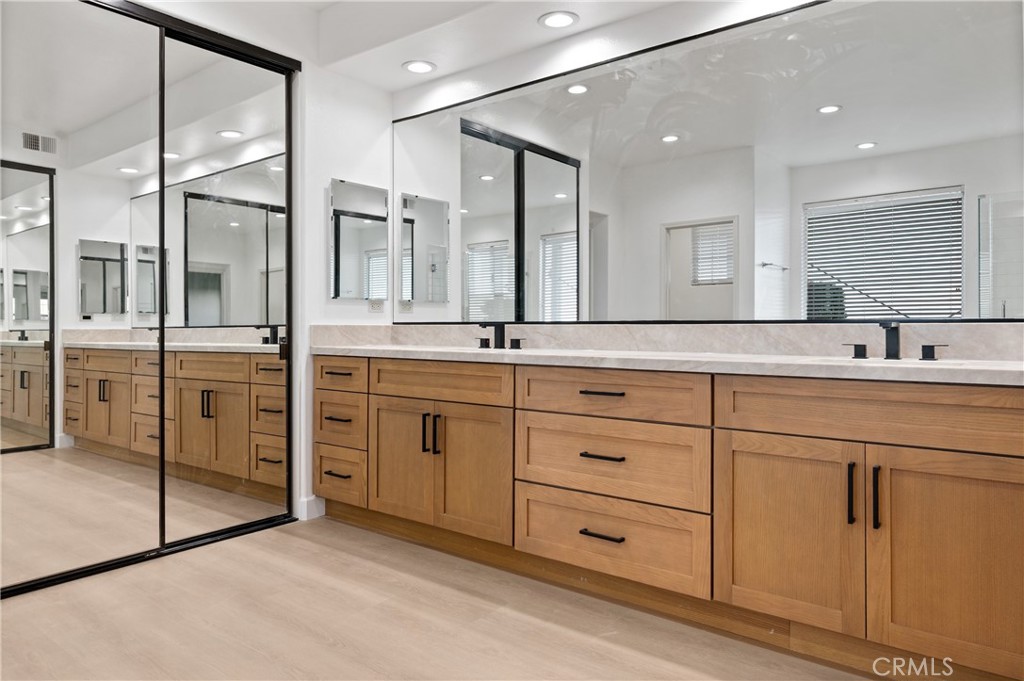 6 Saros, Unit 68 Irvine, CA 92603 - Photo 26 of 35 a bathroom with a double vanity sink a mirror and a shower