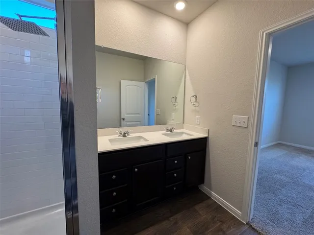 a bathroom with a double vanity sink and mirror