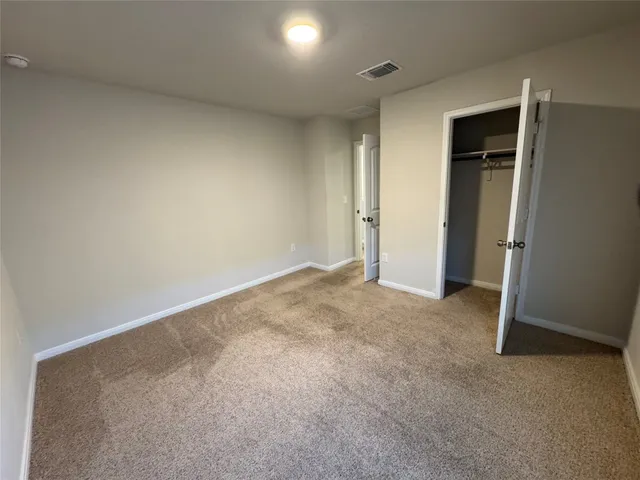 an empty room with closet and wooden door