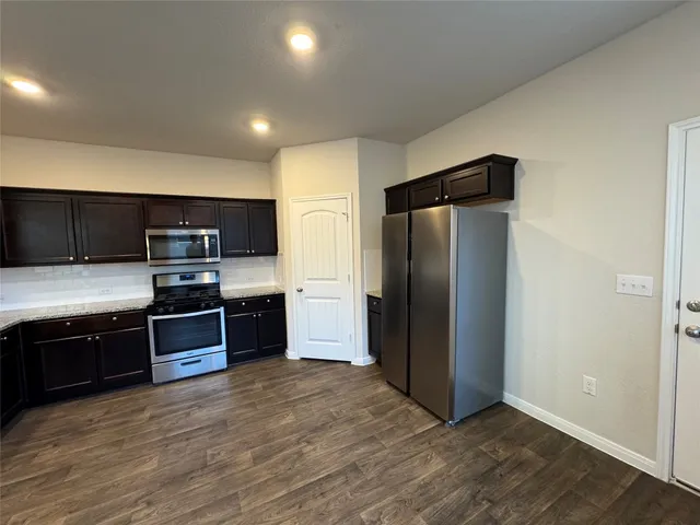 a view of kitchen with microwave and refrigerator