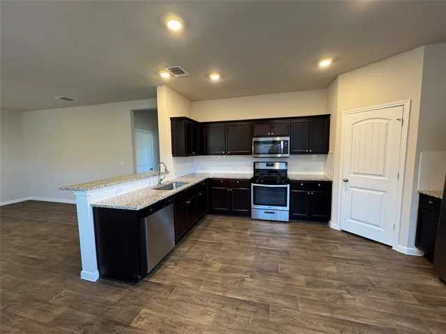 a kitchen with stainless steel appliances granite countertop a refrigerator and a stove