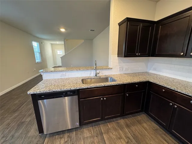 a large kitchen with stainless steel appliances kitchen island granite countertop a sink and cabinets