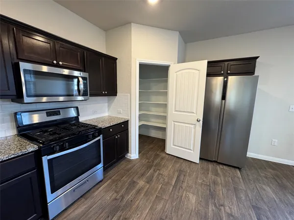 a kitchen with granite countertop a sink and a stove