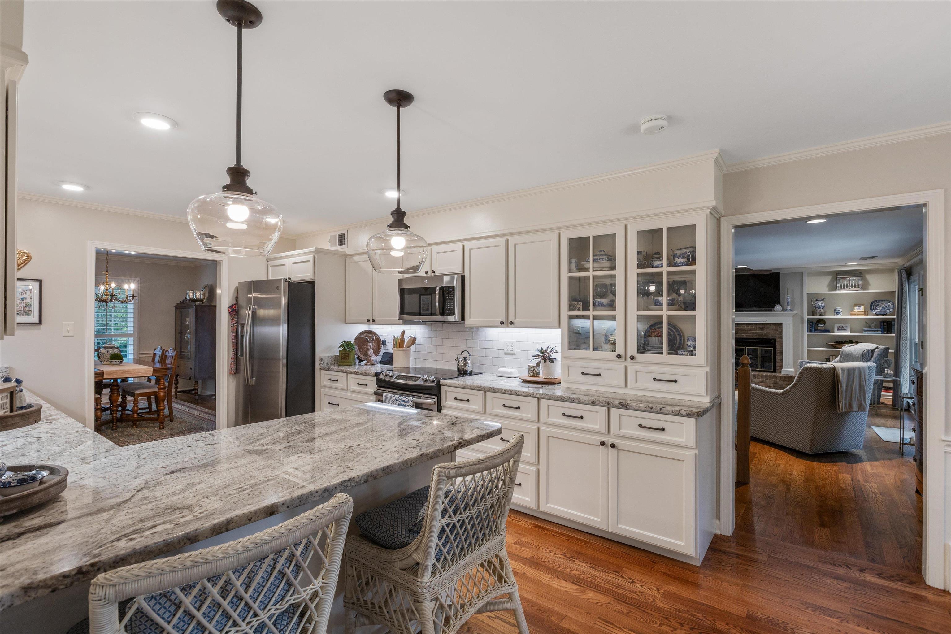 560 Silverman Drive Collierville, TN 38017 - Photo 7 of 31 a kitchen with stainless steel appliances kitchen island granite countertop a table chairs and a wooden floor