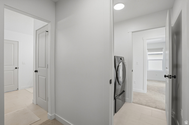 11531 Engelmann Drive Draper, UT 84020 - Photo 19 of 31 Hallway featuring light-toned tile flooring, recessed ceiling lighting, and a modern front-load washer