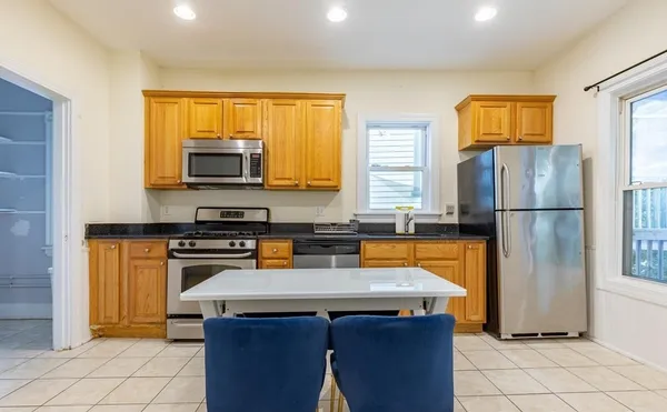 a kitchen with stainless steel appliances wooden cabinets and a refrigerator