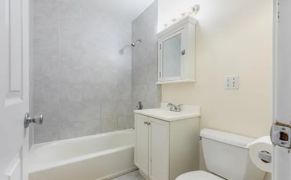 a bathroom with a sink toilet vanity and bathtub