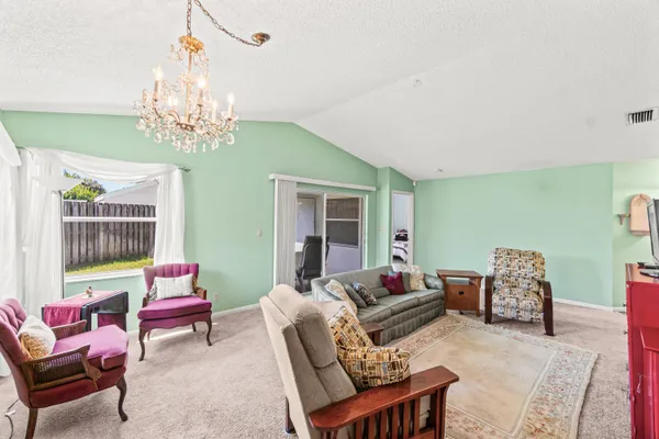 a living room with furniture chandelier and a window