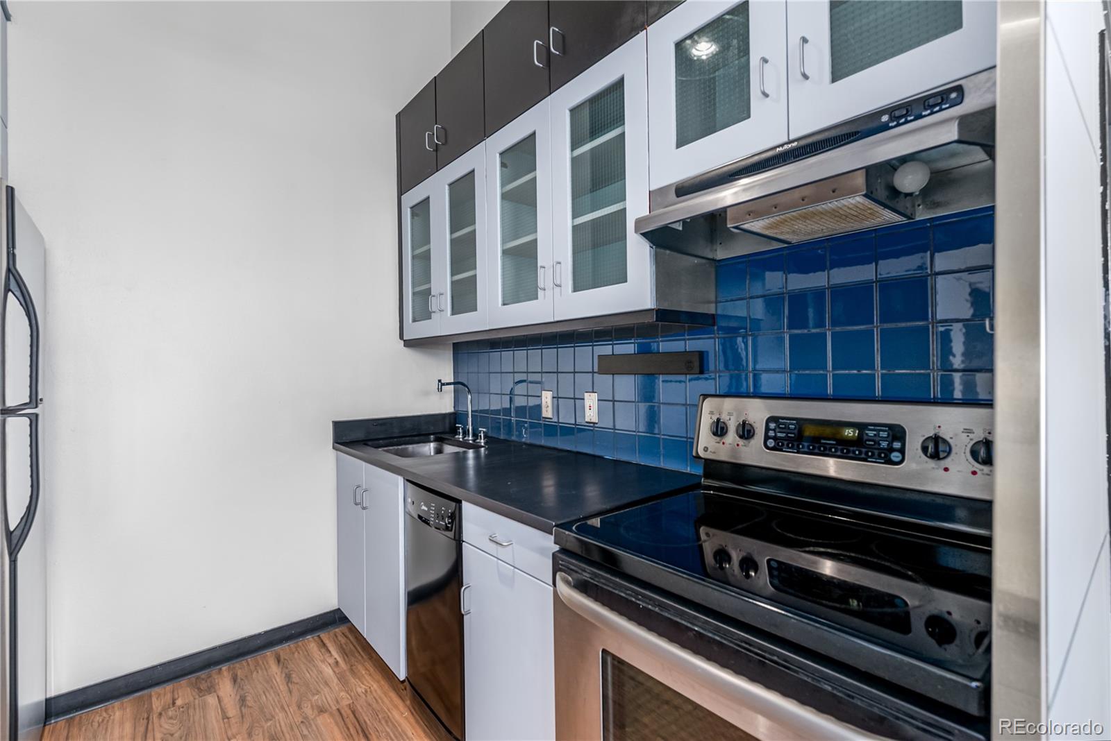 3309 Blake Street, Unit 207 Denver, CO 80205 - Photo 7 of 26 a kitchen with wooden cabinets and a stove top oven