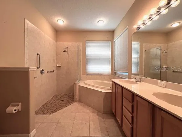 a bathroom with a granite countertop sink a toilet a large mirror and a bathtub