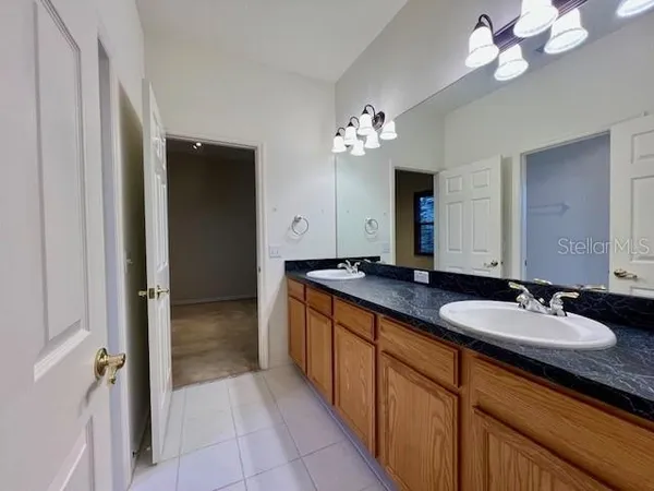 a spacious bathroom with a granite countertop sink a mirror and a shower