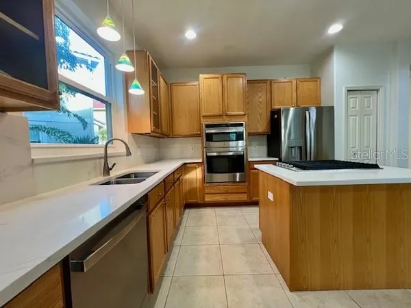a kitchen with stainless steel appliances a sink stove and cabinets