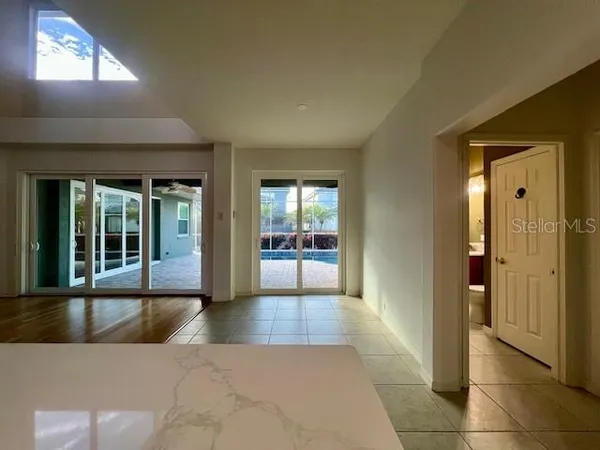a view of a hallway with wooden floor and a living room