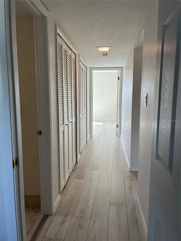 a view of a hallway with wooden floor