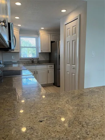 a large kitchen with kitchen island a sink stainless steel appliances and cabinets