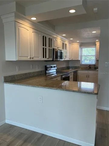 a kitchen with stainless steel appliances granite countertop a sink and a stove