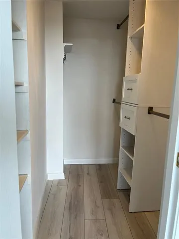 a view of walk in closet with wooden floor