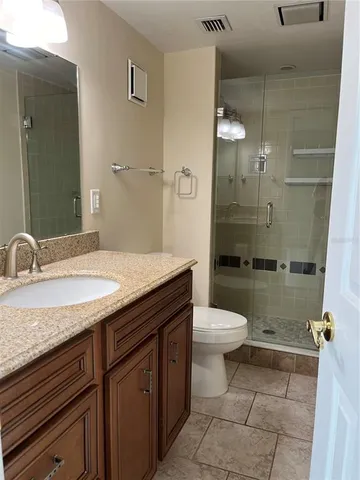 a bathroom with a granite countertop sink toilet and shower