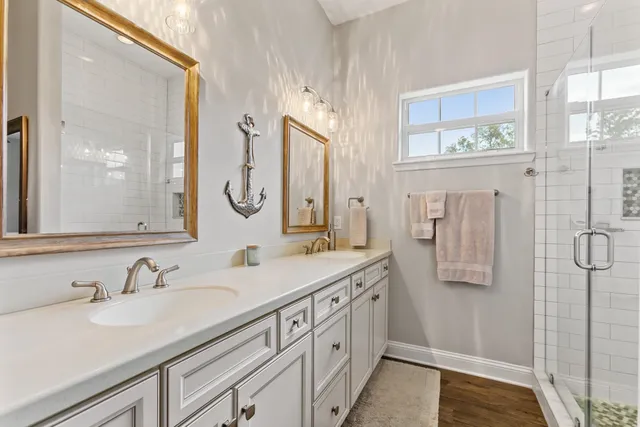 a bathroom with a double vanity sink a mirror and a shower