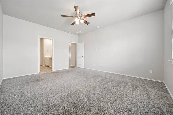 an empty room with a ceiling fan and a window
