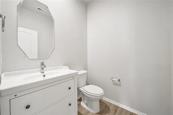 a bathroom with a toilet a sink and mirror