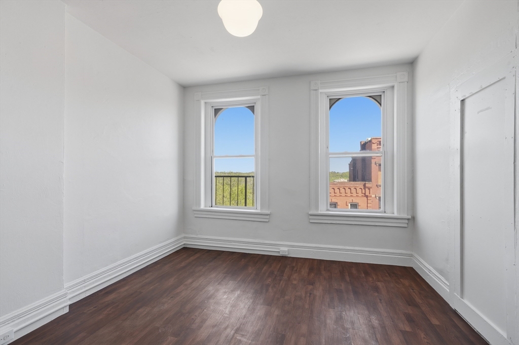 105 High Street, Unit 4P Holyoke, MA 01040 - Photo 8 of 11 an empty room with wooden floor and windows