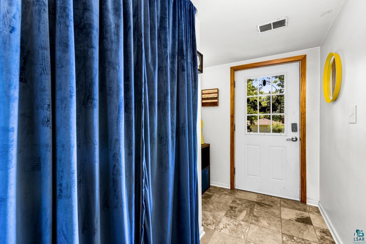 4119 Pitt Street Duluth, MN 55804 - Photo 50 of 50 Entryway featuring a white door with a window pane insert, wood-finish trim, and neutral-toned tile flooring