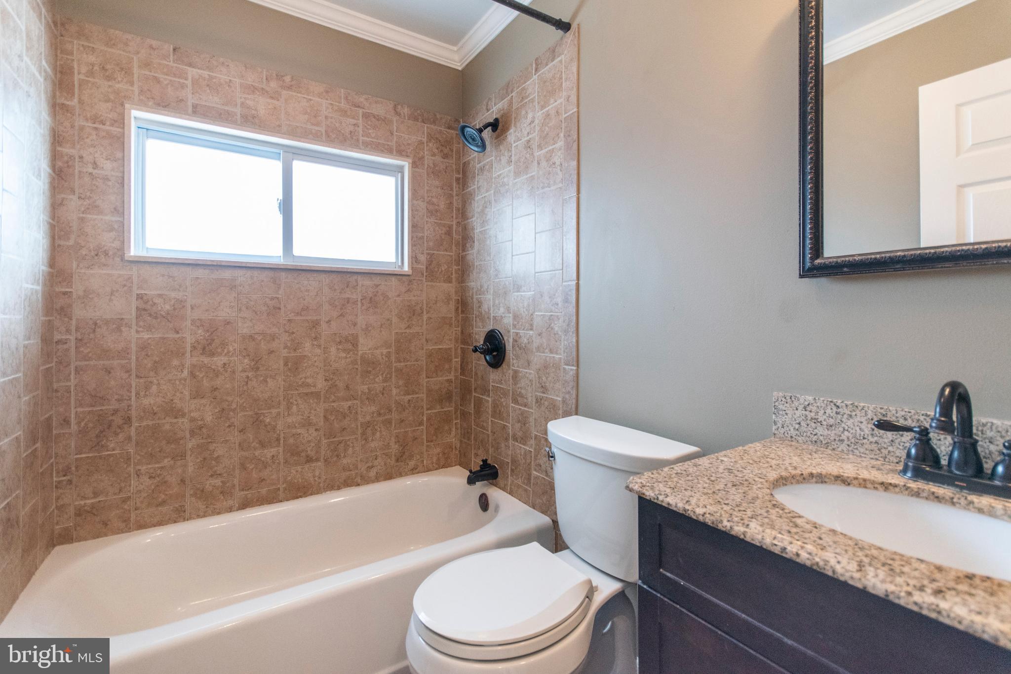 32 Gentle Road Levittown, PA 19057 - Photo 28 of 32 a bathroom with a granite countertop toilet a sink and bathtub