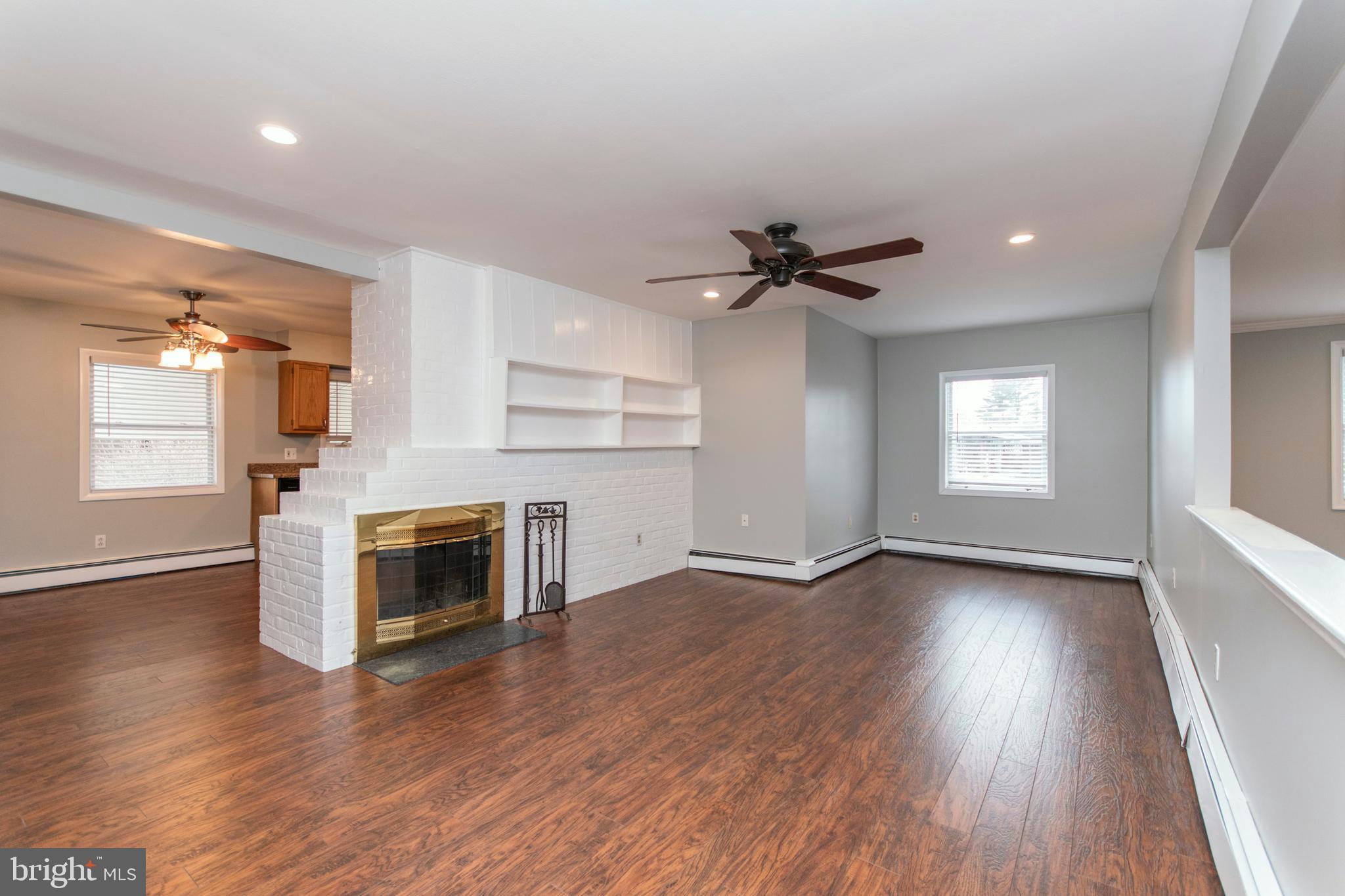 32 Gentle Road Levittown, PA 19057 - Photo 8 of 32 an empty room with wooden floor a fireplace and windows