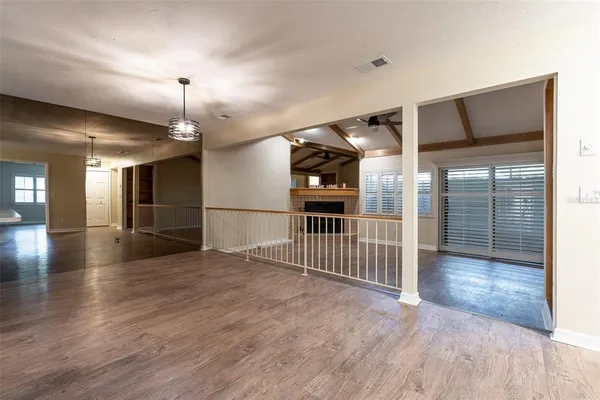 an empty room with wooden floor and fireplace