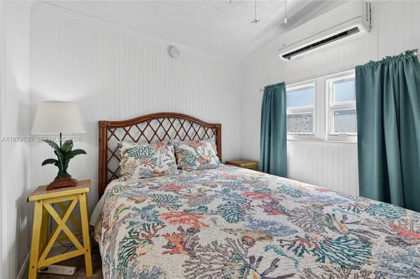 a bedroom with a bed next to a window and a flat screen tv