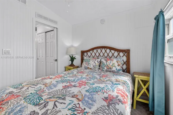 a bedroom with a bed and a painting on the wall