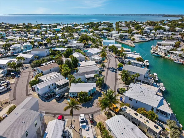 an aerial view of a city with lots of residential buildings and ocean view in back