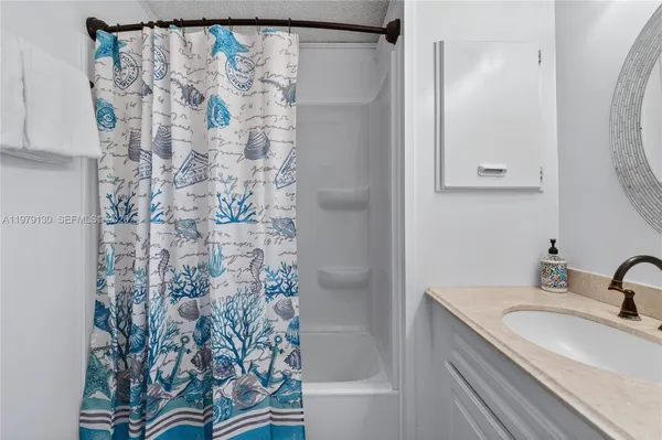 a bathroom with a granite countertop sink a shower and a mirror