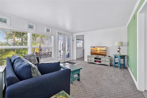 a living room with furniture a flat screen tv and a large window