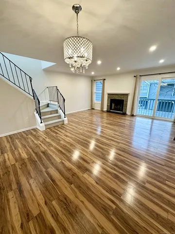 a view of empty room with wooden floor and fireplace