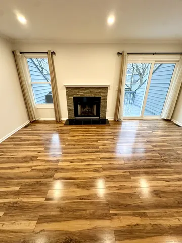 a view of empty room with wooden floor and fireplace